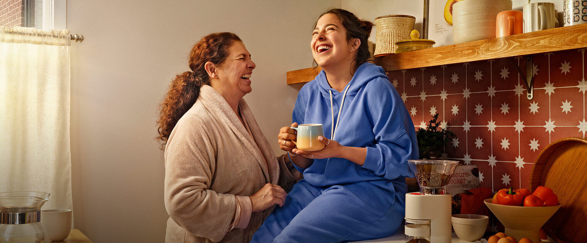 Image of a mother and young adult daughter laughing